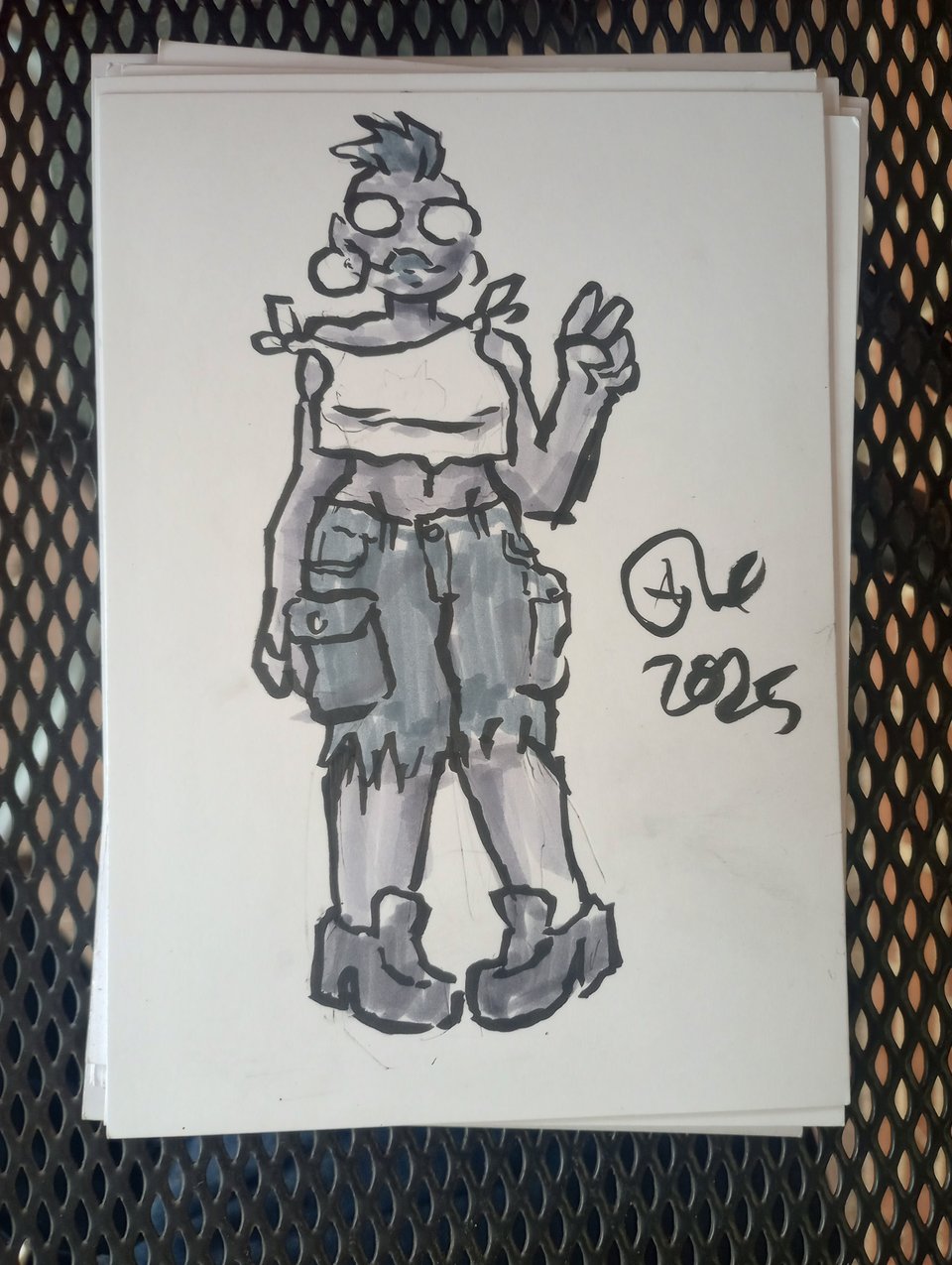 Val in a chopped up tee, chunky loafers, and cargo pants that have been cut into below-the-knee shorts