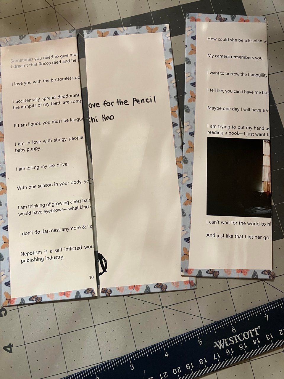 Three DIY bookmarks: folded-in-half pages from a book, clued to card stock and bordered on three sides with washi tape with a butterfly theme.