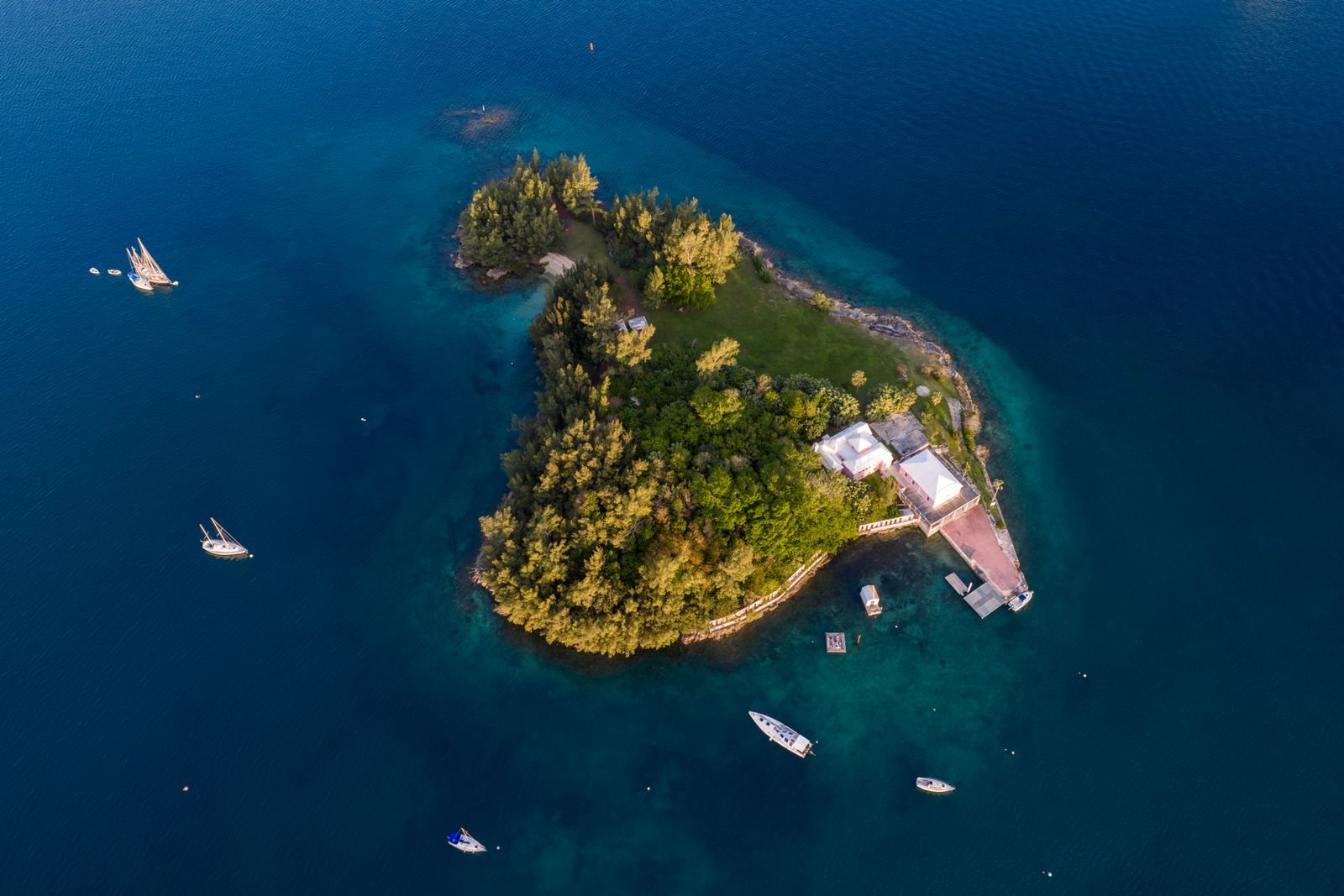 Aerial view of a Bermuda island surrounded by sailboats and crystal-clear water