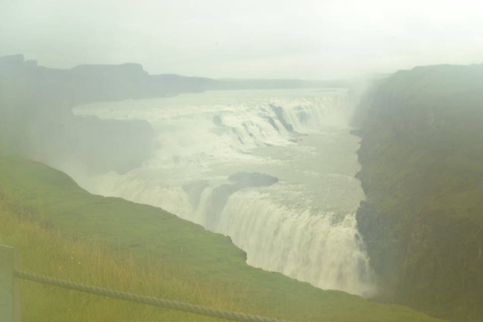 A spectacular waterfall seen from above, shrouded in mist.