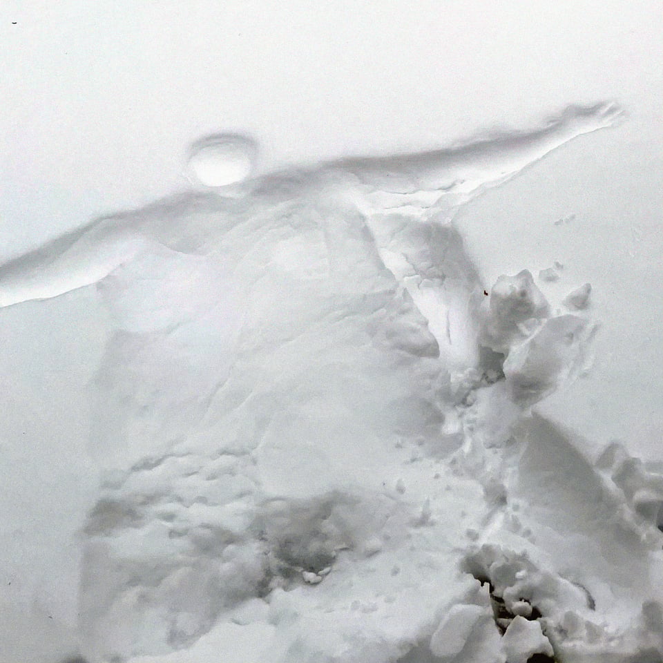 an imprint left in the snow after a large sweaty person laid down in it