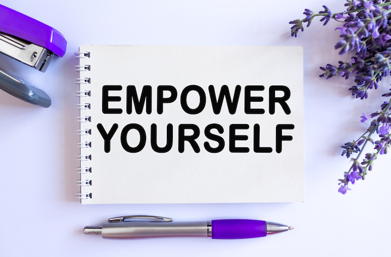 The words 'Empower Yourself' on a notepad showing a stapler, pen and lavender flowers in the background.