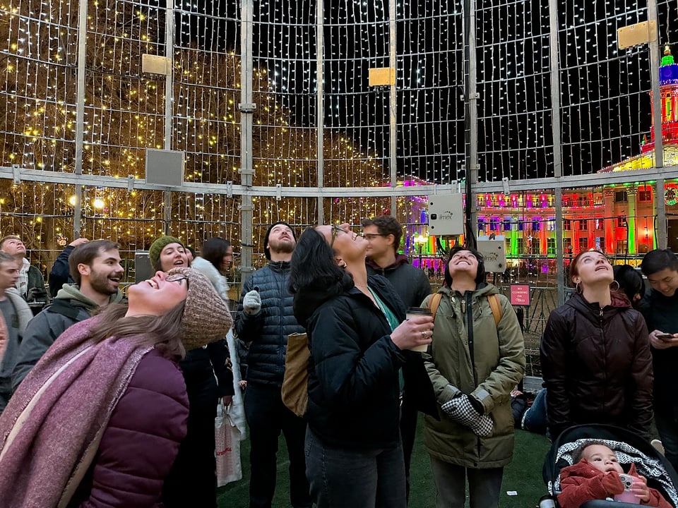 A lot of people standing inside a Christmas tree.