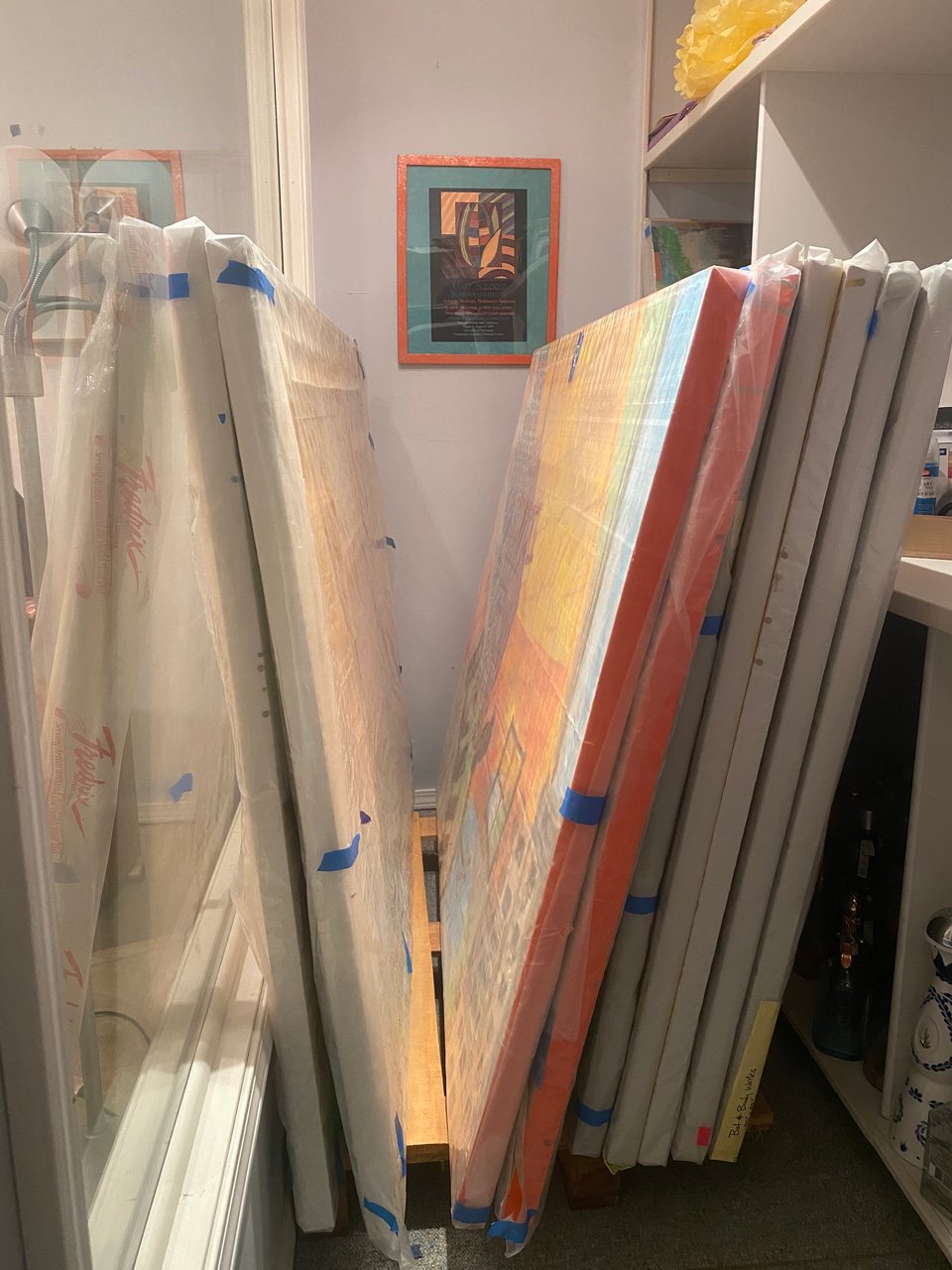 paintings piled and wrapped in storage wishing they were on walls instead