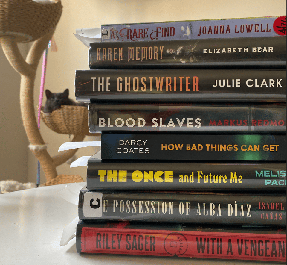 A stack of books: A Rare Find, Karen Memory, The Ghostwriter, Blood Slaves, How Bad Things Can Get, The Once and Future Me, The Possession of Alba Diaz, and With a Vengeance. There's some kind of creature in the background but he's not associated with this.