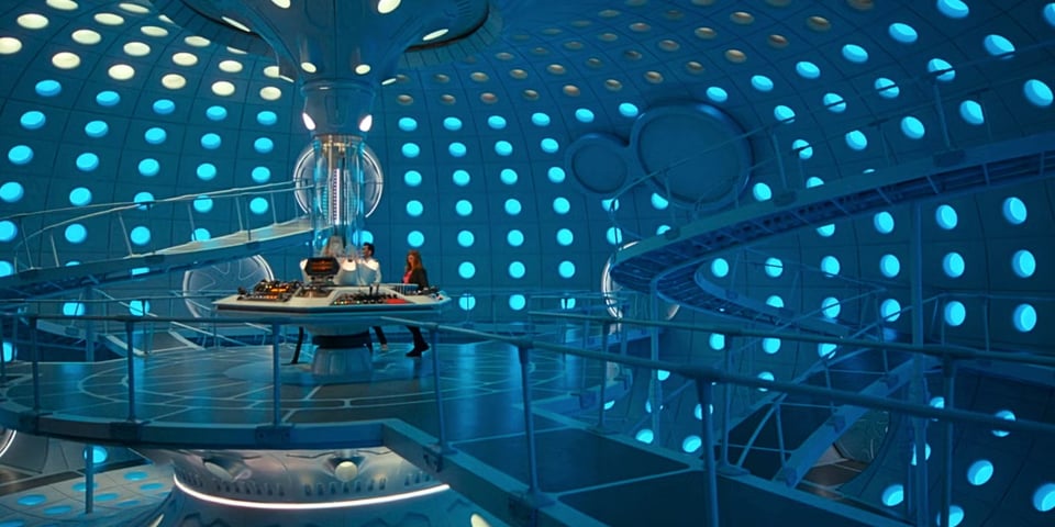 The interior of the TARDIS, with tons of blue circles on the walls and swooshy walkways around the traditional hexagonal control console.