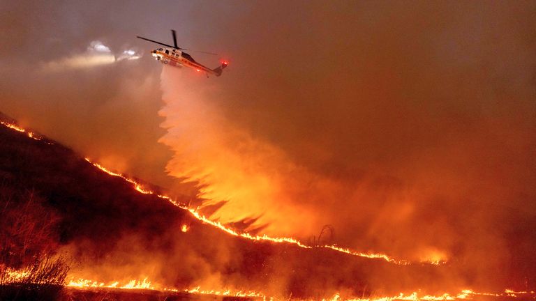 Photo of a firefighting helicopter dropping water or fire retardant