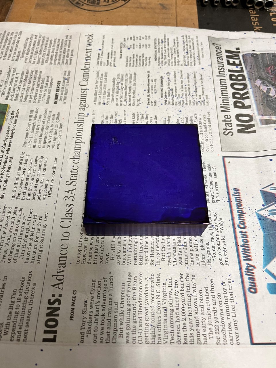 Block of aluminum sitting on newspaper