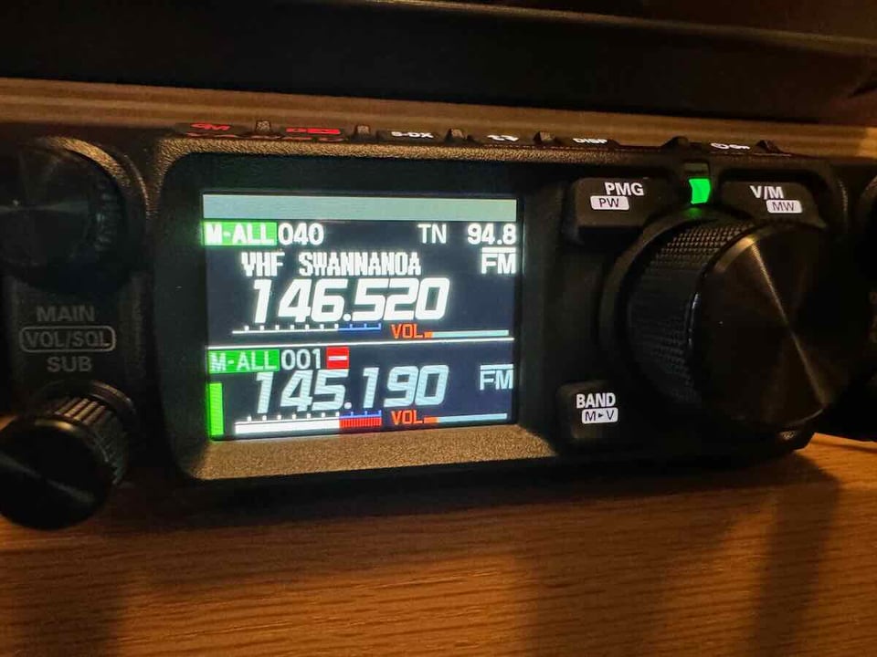 Amateur radio showing a lit-up digital display, which prominently shows "VHF SWANNANOA 146.520 94.8 FM".