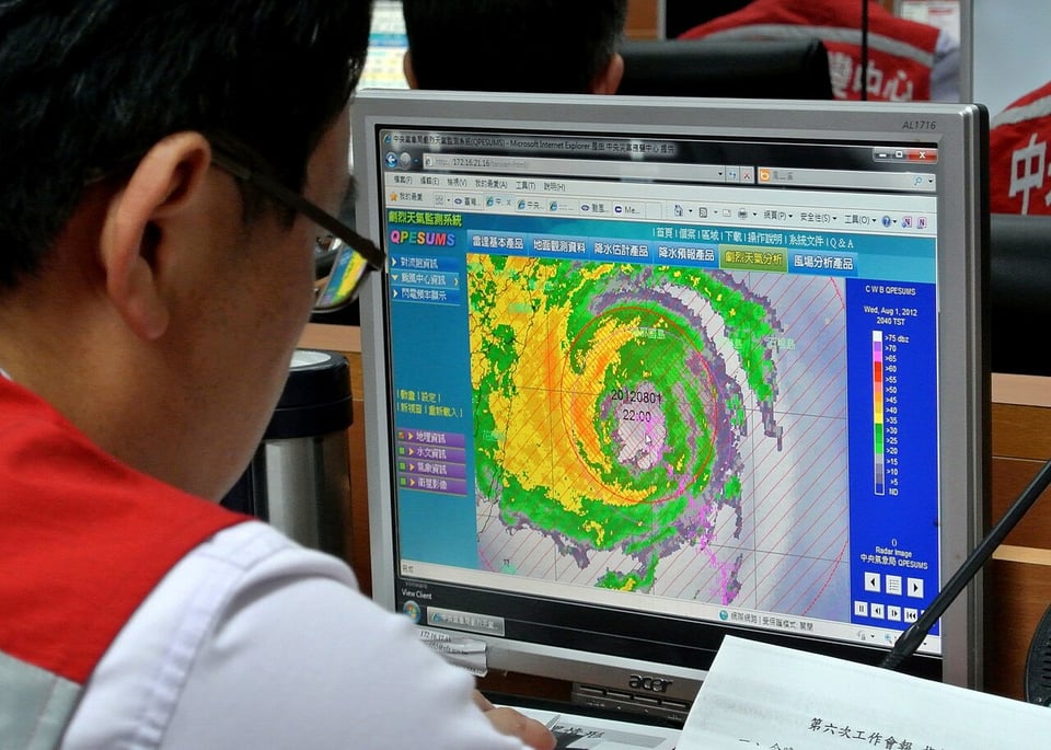 A person looks at a weather map on a computer screen.  Source:  Taiwan Presidential Office / 總統府, CC BY 2.0 <>, via Wikimedia Commons)