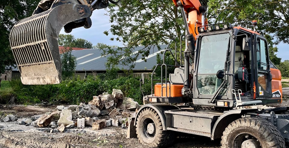 Graafmachine verwijdert beton