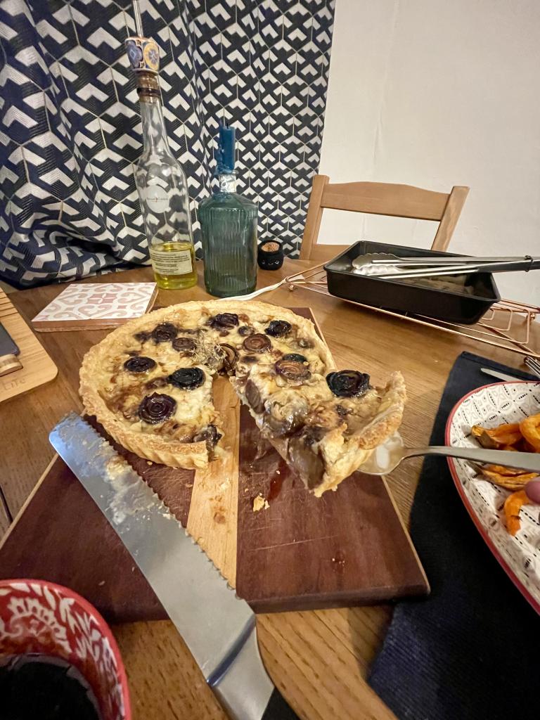 A slice of onion tart being brought away from the tart