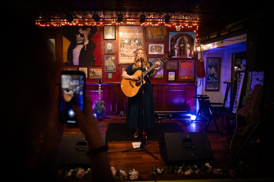 Emily Henry playing guitar and singing in a Santa Cruz, California venue