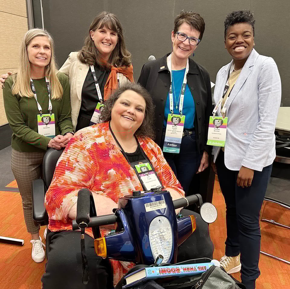 Five authors smile for camera at conference