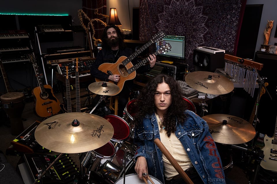Kevin Comeau (in the back with a double neck guitar) and Cody Bowles (front) in their studio.