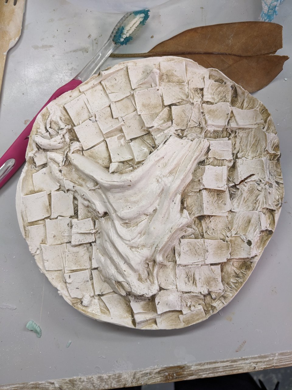 A plaster cast made from imprints of a piece of wood, and a repeated square pattern