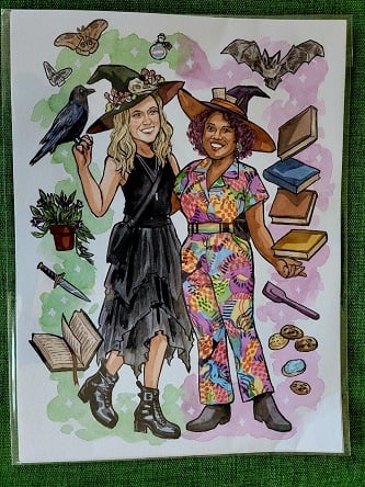 Watercolor painting of Patricia and her wife Nicole as witches. Floating around them are books, a bat, moths, a knife, cookies, a spatula, and a plant.