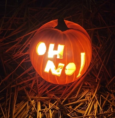 Pumpkin with the words “oh no” carved into it and it is lit from inside with a light bulb