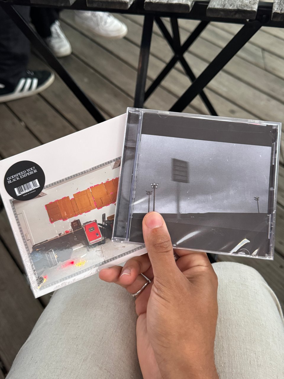 my hand holding two godspeed you black emperor CDs, NO TITLE AS OF 13 FEBRUARY 2024 28,340 DEAD and F#A#∞