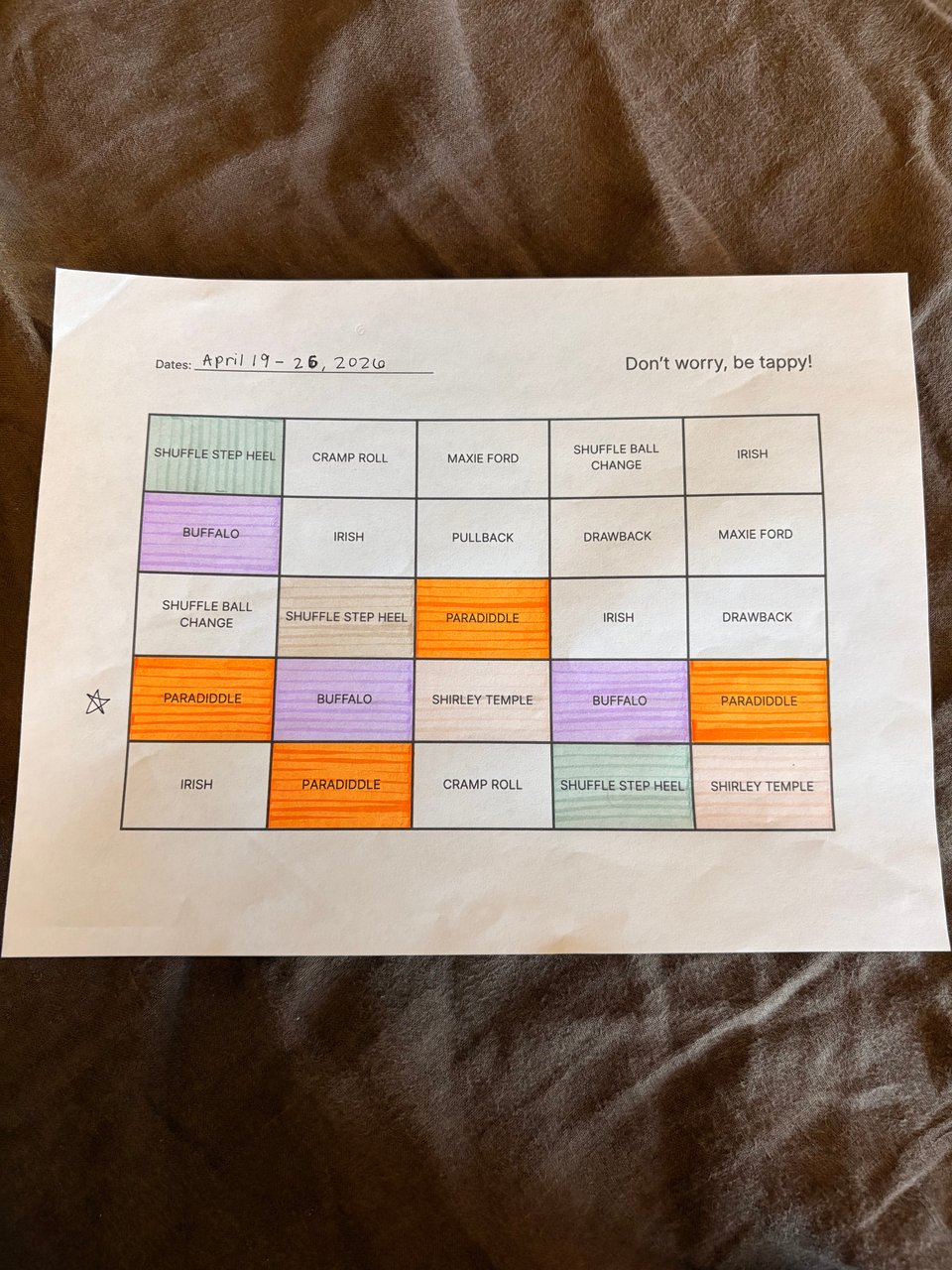 A white piece of paper with tap dance bingo on it. Highlighted boxes include tap dance combinations Paradiddle, Buffalo, Shirley Temple, and Shuffle Step Heel.