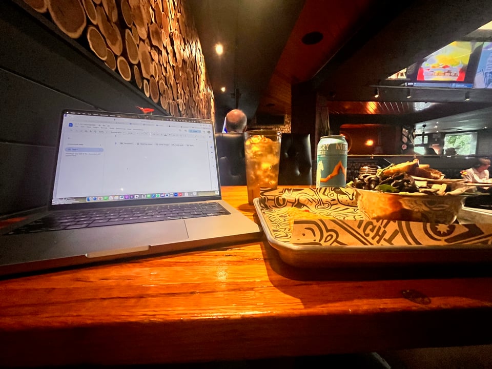 My laptop and lunch on a table at the pizza shop