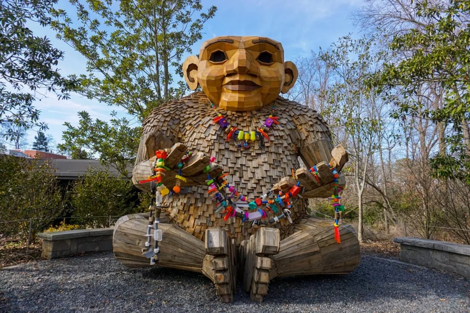 An enormous wooden troll sculpture in the woods