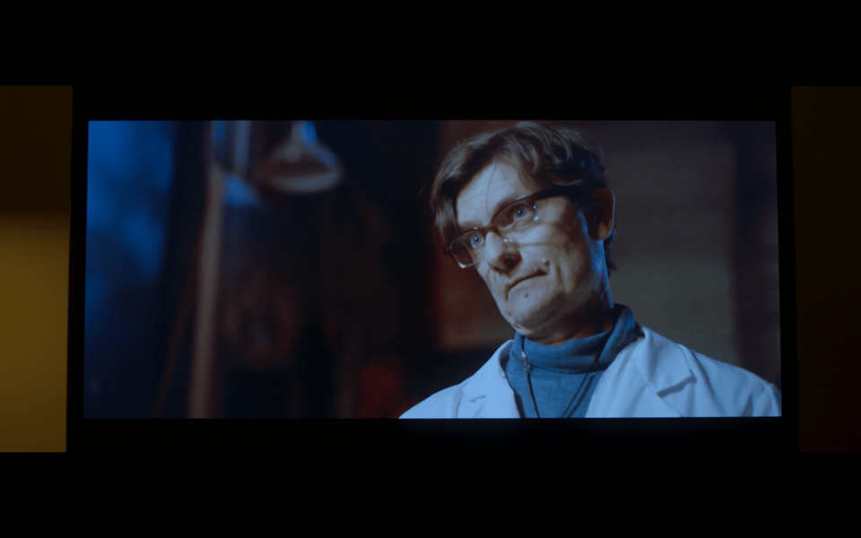 A screenshot of an image on a television. The actor James Urbaniak stares questioningly at someone off camera