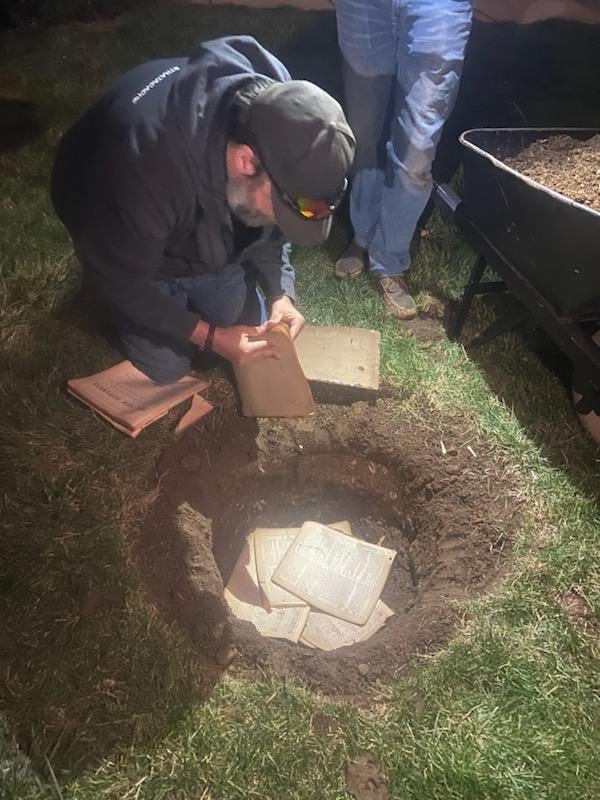 Our steward, Adam, literally planting pages from the God's word beneath a new flowering dogwood going in on the east side of the church.
