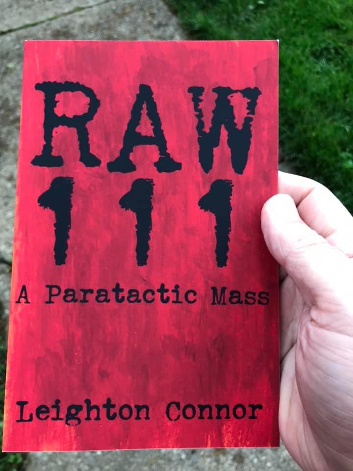 My hand holding my book RAW 111, this is an image I posted on Instagram 6 years ago and I used a filter on it so the colors are EXTREME, it's not actually that bright in real life. But anyway it's a red cover with black letters on it.