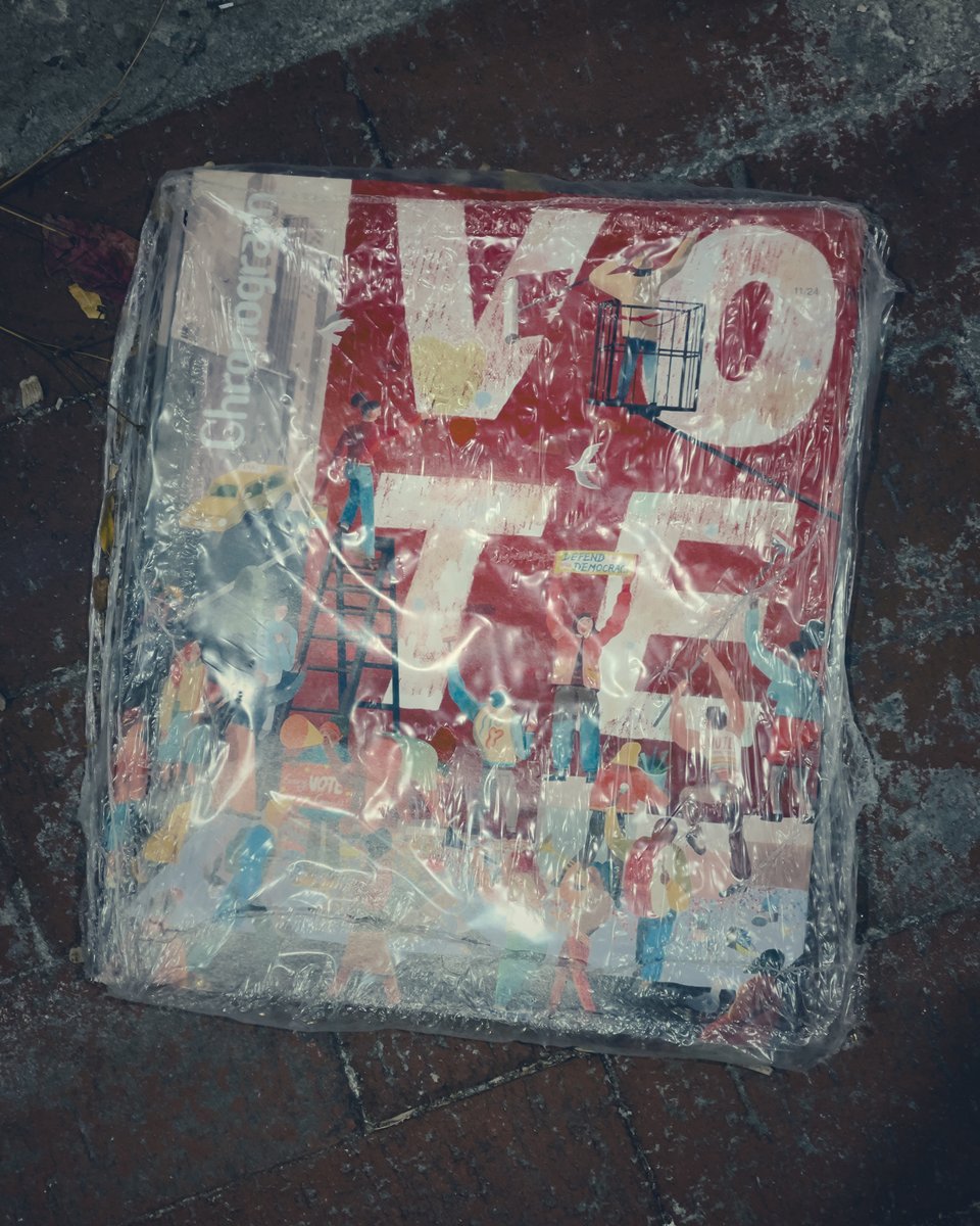 Photograph of a magazine cover wrapped in plastic. The word "VOTE" in big white capital letters is the cover image.
