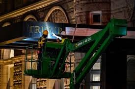 Construction workers removing branding from what was the Trump International Hotel in 2022. Many Americans don’t want to be associated with the Trump brand.