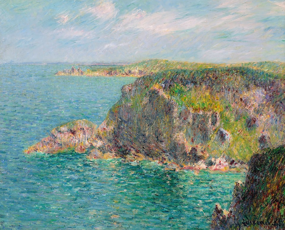 a cliff overlooking the green and blue ocean