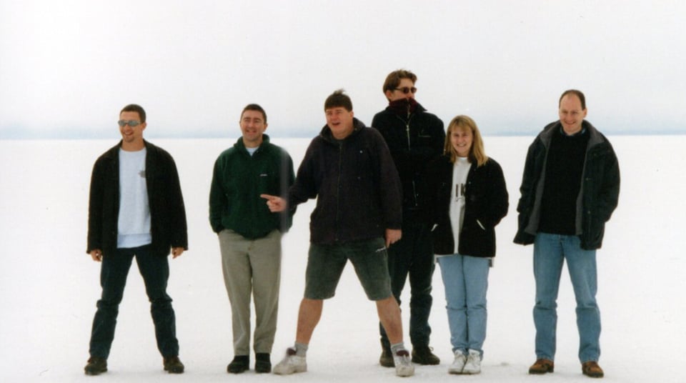 A group photograph. Six people in an all-white landscape. There are five men and one woman.