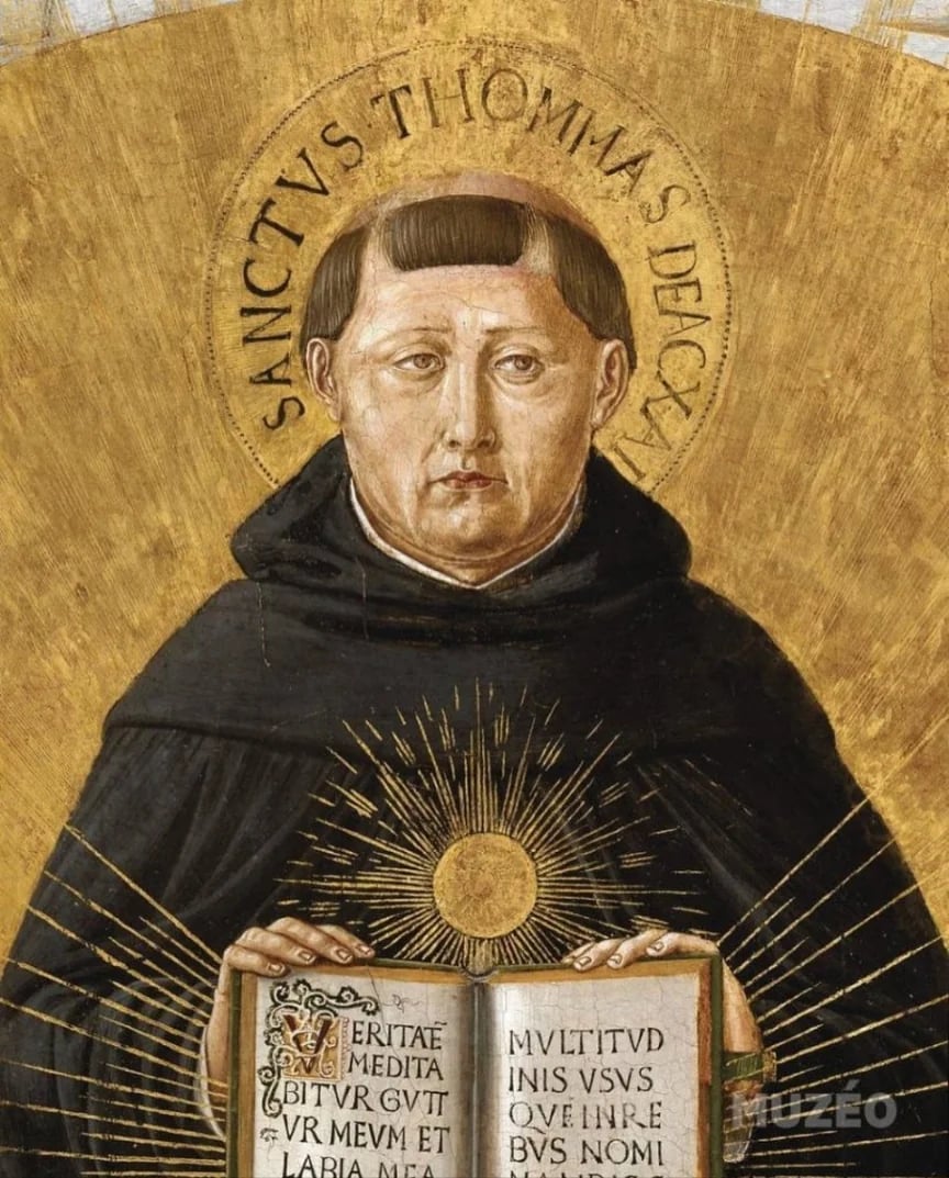 A golden image of St. Thomas Aquinas holding open a book. He's got a lot of side eye going on.