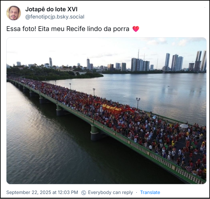 Post de Jotapê do lote XVI (@fenotipcjp.bsky.social) com o texto: Essa foto! Eita meu Recife lindo da porra ❤️ (imagem mostra uma grande multidão de pessoas reunida na Terceira Ponte, ponto central de Recife, sobre o rio Capibaribe, com a paisagem urbana do Recife ao fundo)
