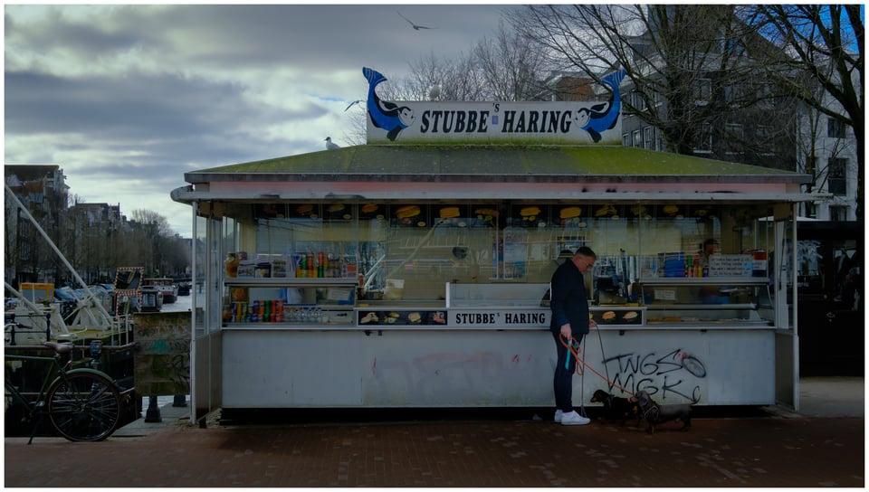 A man standing in front of a food stall.