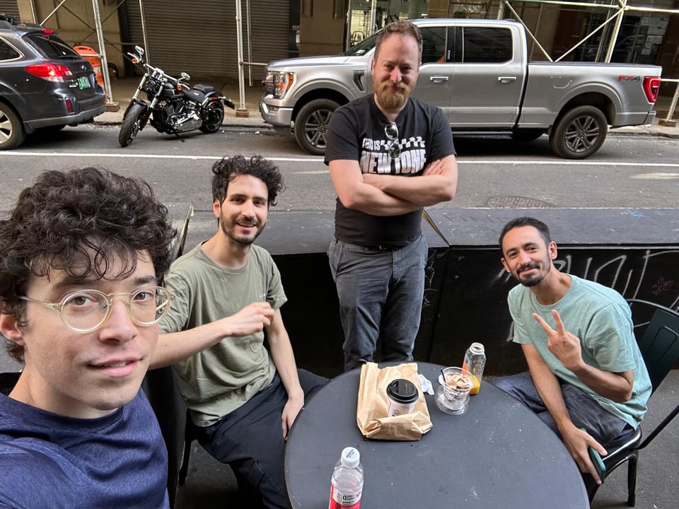 Our core dev team of four eating bagels on the streets of Manhattan, smiling for the camera