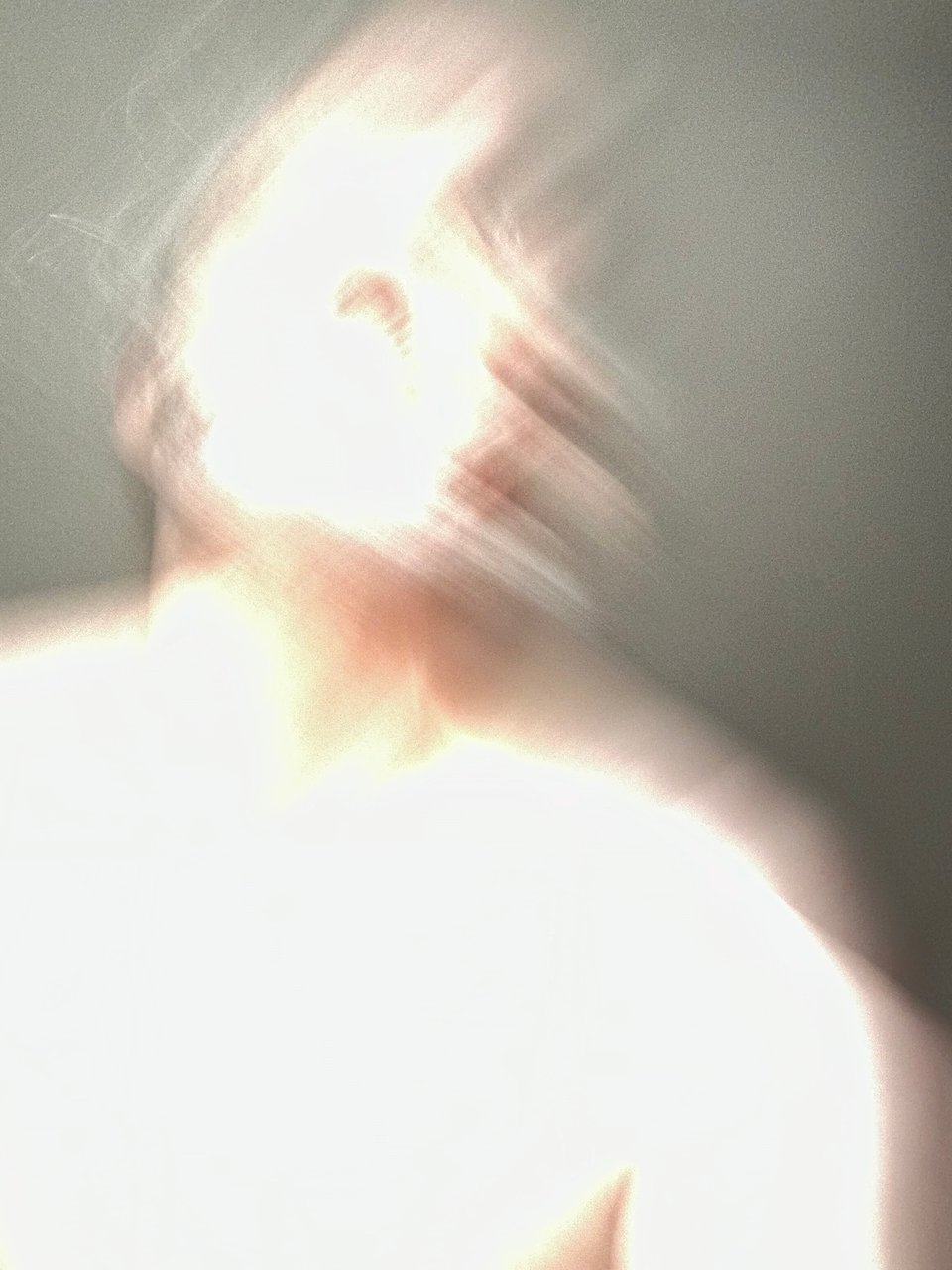blurry, glare photo of a shirtless man reaching to catch the cameraphone