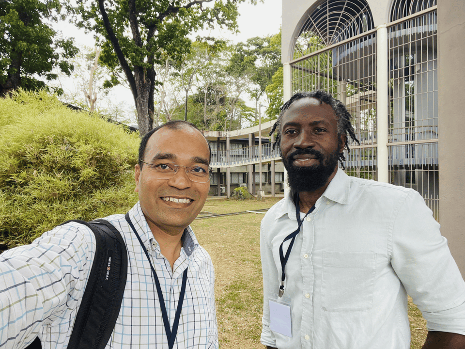 Kailas and Nigel in front of the university, posing for a selfie made by Kailas.