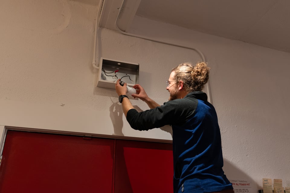 Jim changing an exit sign lightbulb.