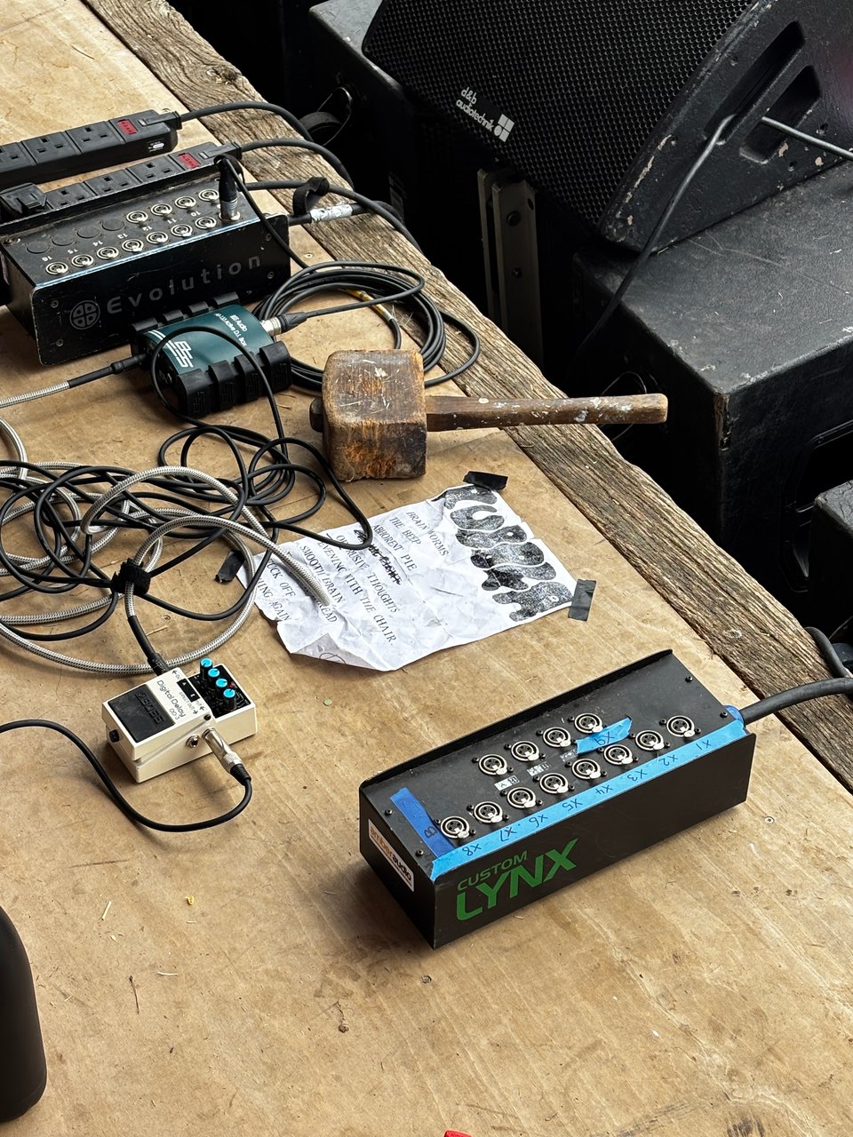 The floor of The Shed stage at Supernormal before Rubber's performance, with setlist, BOSS digital delay pedal and cartoon sized mallet.