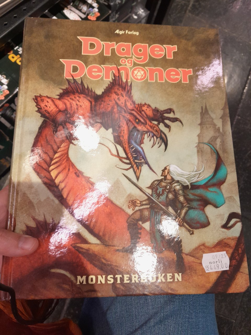Autre couverture de Dragon og demoner présentent un dragon combatant un guerrier le tout dans une ambiance brune un peu aquarelle