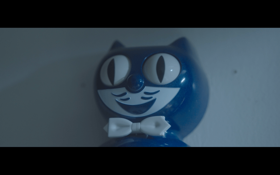 A screenshot of a close up film shot of a blue Kiity-Cat Clock's face