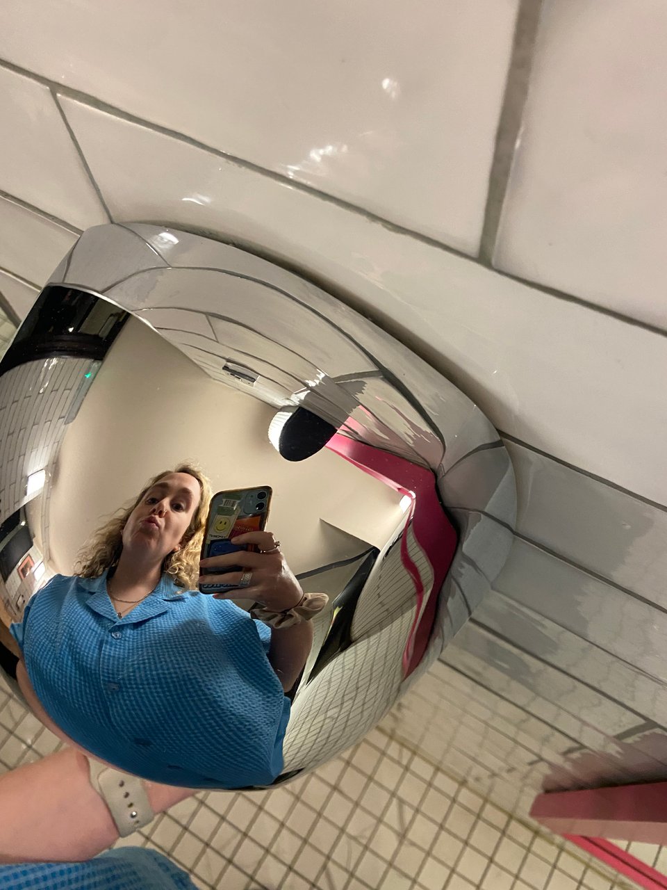 a woman taking a selfie in a hand dryer