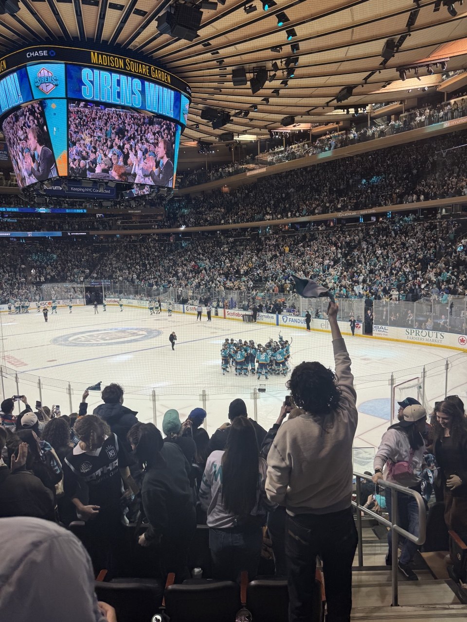 A picture of Madison Square Garden from the lower bowl seats as the New York Sirens hockey team gathers to celebrate their win.