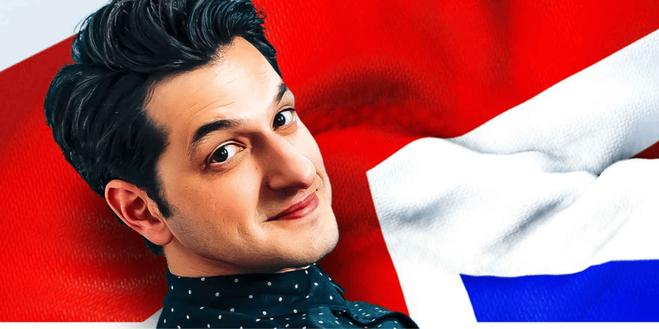 Improviser Ben Schwartz in front of a Union Jack flag.