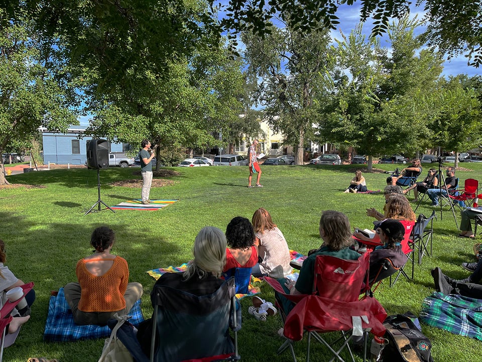 Iván presenting to a crowd in a park.