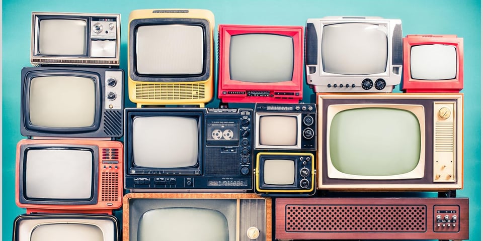 A stack of old TVs in bright colours.