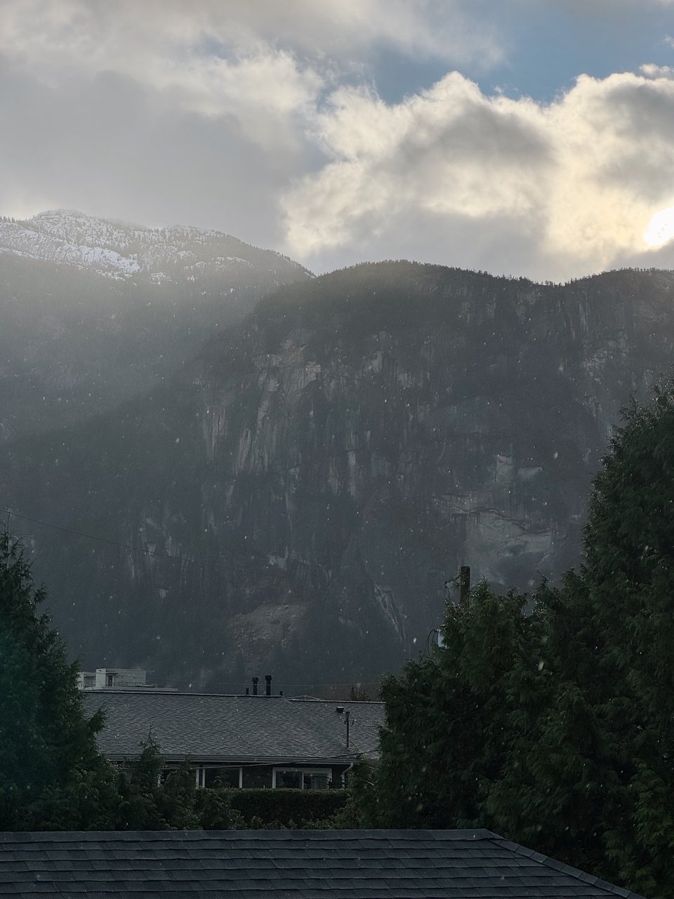 An image of a monolith, with sunlight breaking through cloud cover as large raindrops fall