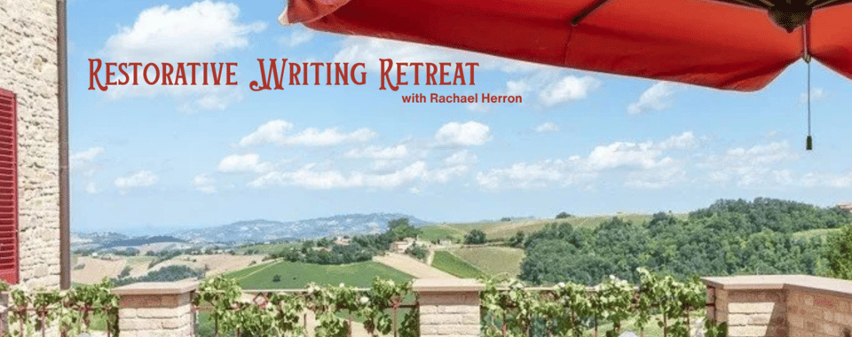 image of italian countryside seen from the writing retreat hotel, red umbrella above, green hill in background